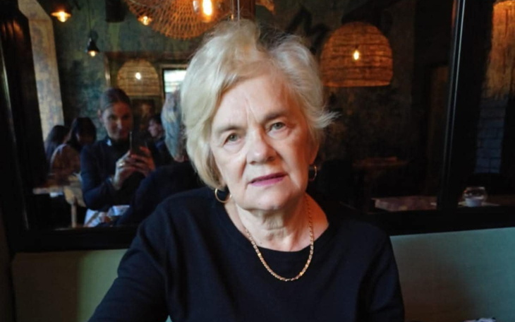 Starsza kobieta w restauracji, z poważnym wyrazem twarzy.