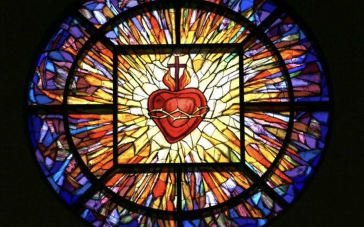 Witraż przedstawiający serce otoczone promieniami.