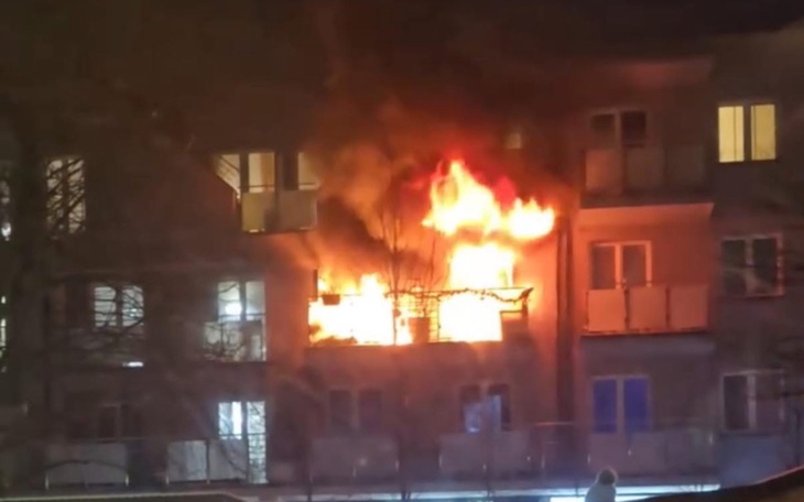 Pożar na balkonie budynku mieszkalnego w nocy.