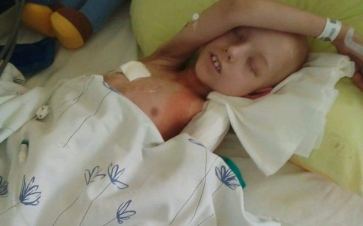 Chłopiec w szpitalnym łóżku, z wyraźnym zmęczeniem.