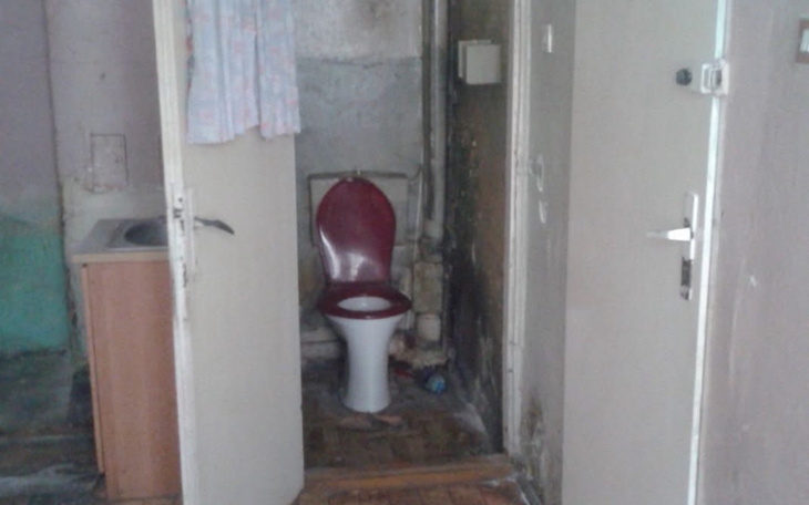 Zniszczona toaleta w zaniedbanym pomieszczeniu.