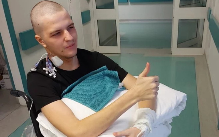 Młody mężczyzna w szpitalu, pokazujący kciuk w górę.