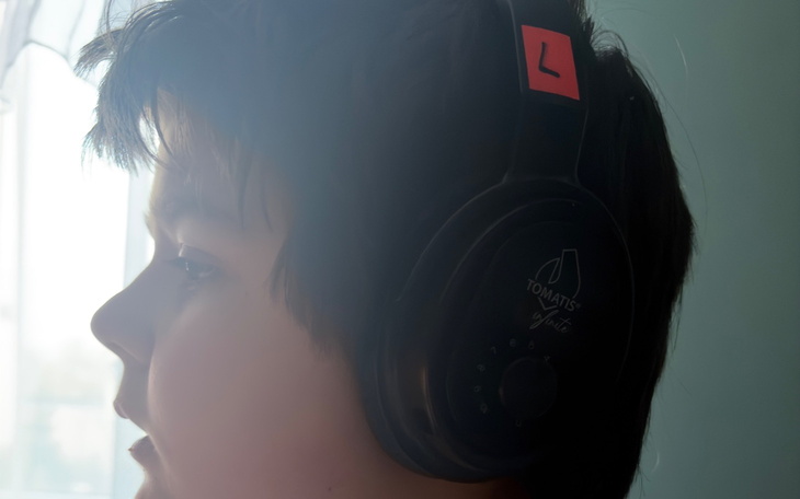 Chłopiec w słuchawkach, skupiony na dźwiękach.