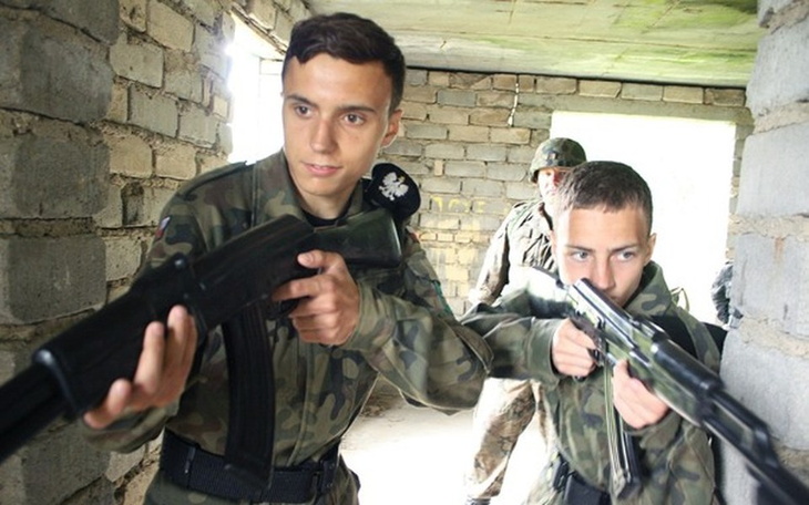 Zespół graczy w akcji, z bronią w grze komputerowej.