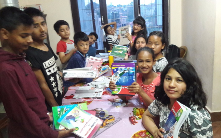 Grupa dzieci z książkami w rękach, uśmiechnięte.