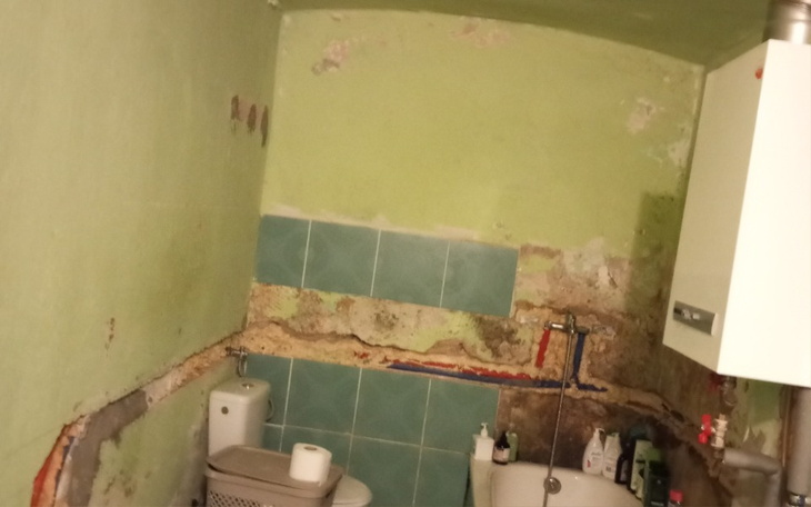 Zniszczona łazienka z widocznymi ścianami.