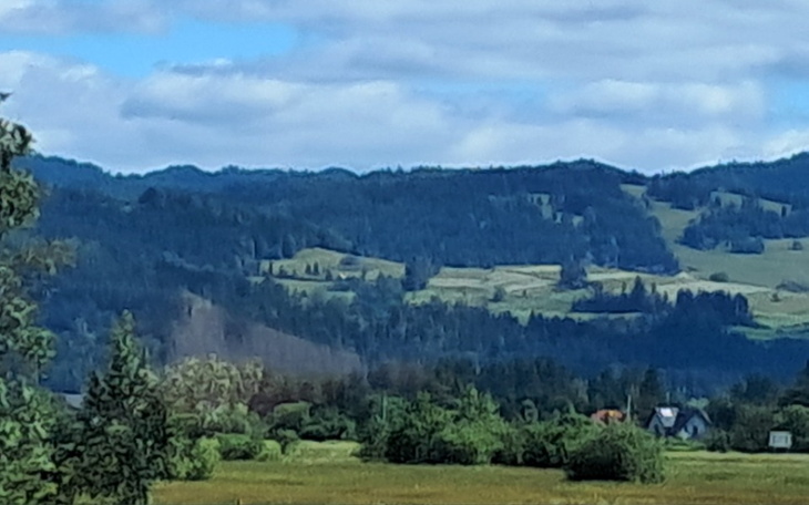 Malowniczy krajobraz górski z zielonymi wzgórzami.
