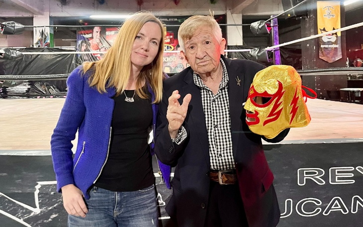 Osoba z maską zapaśniczą, pozująca z legendą wrestlingu.