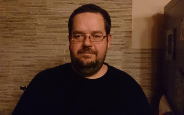 Mężczyzna w okularach z poważnym wyrazem twarzy.