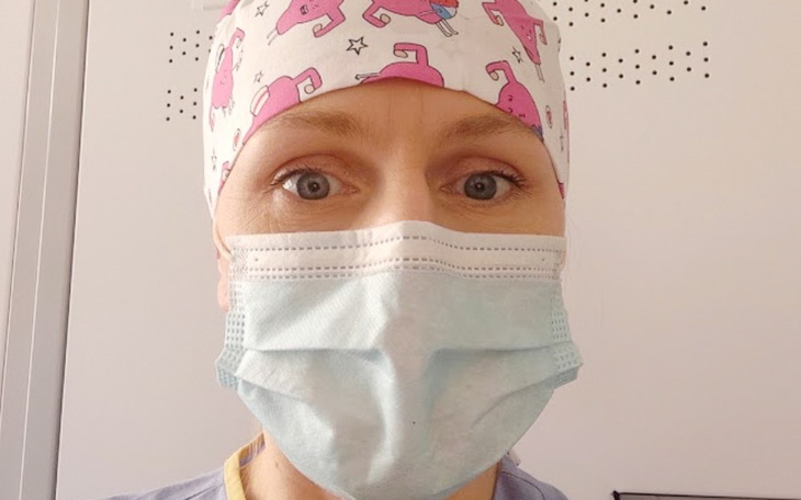 Osoba w maseczce i czepku medycznym.