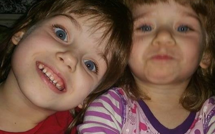 Dwie uśmiechnięte dziewczynki pozujące do zdjęcia.