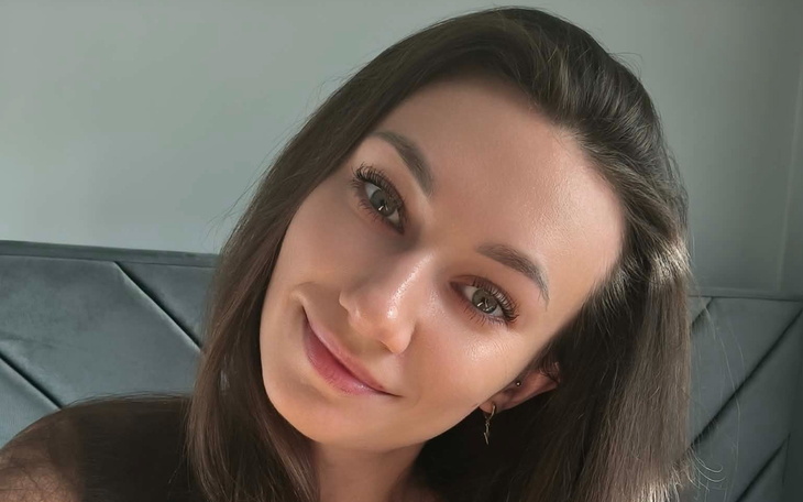 Portret uśmiechniętej kobiety z długimi włosami.