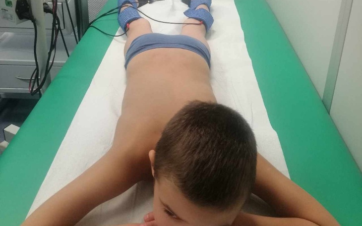 Chłopiec leży na stole, przygotowując się do badania w szpitalu.