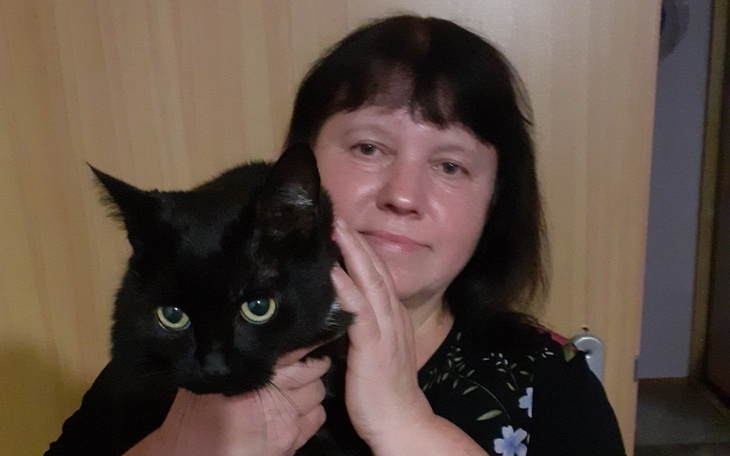 Kobieta trzymająca czarnego kota.