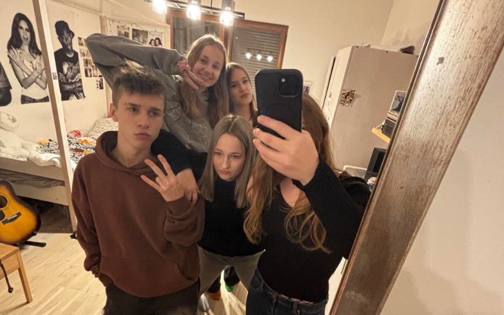 Grupa młodych ludzi pozująca do selfie w lustrze.