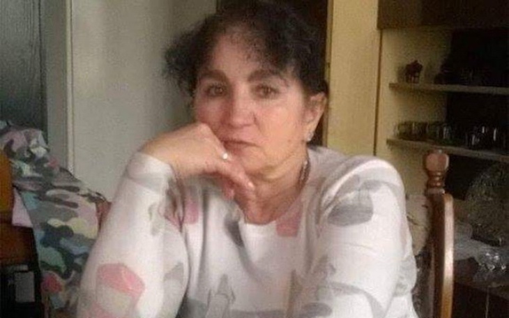 Kobieta siedząca przy stole, z zamyśloną miną.