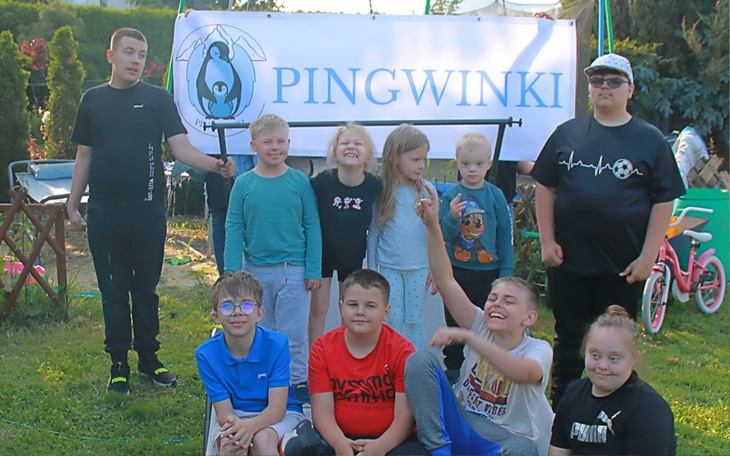 Grupa dzieci pozująca przed banerem z napisem Pingwinki.