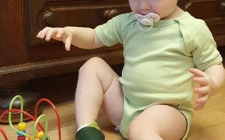 Małe dziecko bawiące się kolorowymi zabawkami na podłodze.