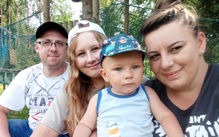 Rodzina pozująca do zdjęcia w parku.