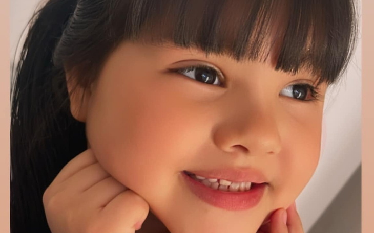 Uśmiechnięta dziewczynka z długimi włosami.