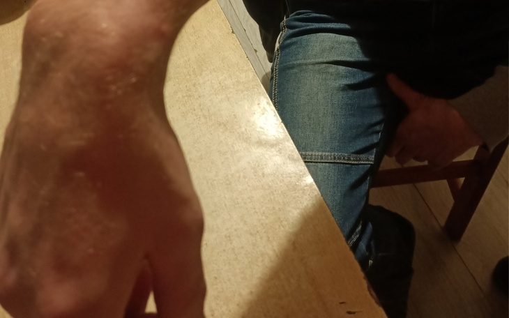 Zbliżenie na rękę mężczyzny trzymającego się stołu.