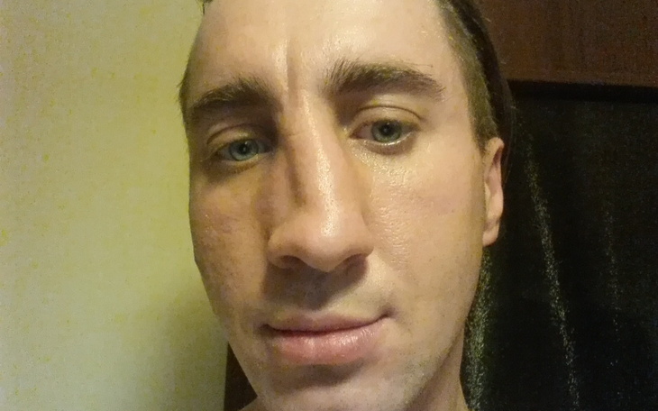 Mężczyzna z bliskiego planu, patrzący w kamerę.