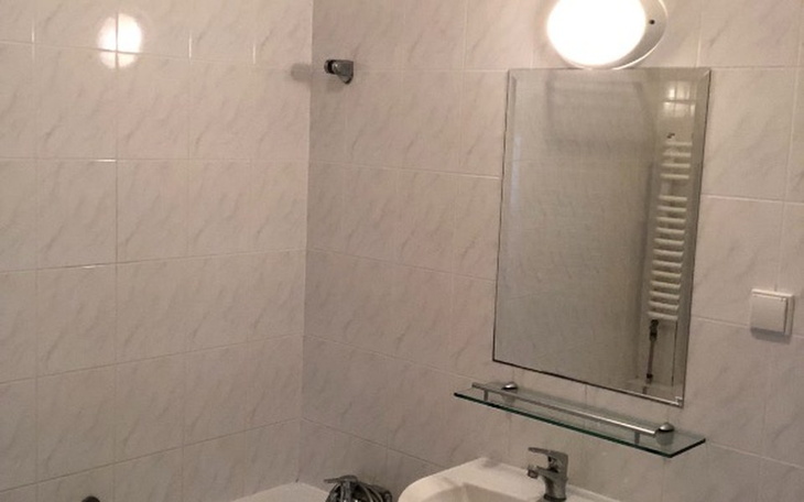 Łazienka z wanną i lustrem, w jasnych kolorach.