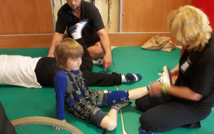 Chłopiec w sprzęcie rehabilitacyjnym, podczas terapii.