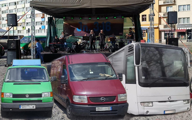Trzy pojazdy dostawcze na scenie podczas koncertu.