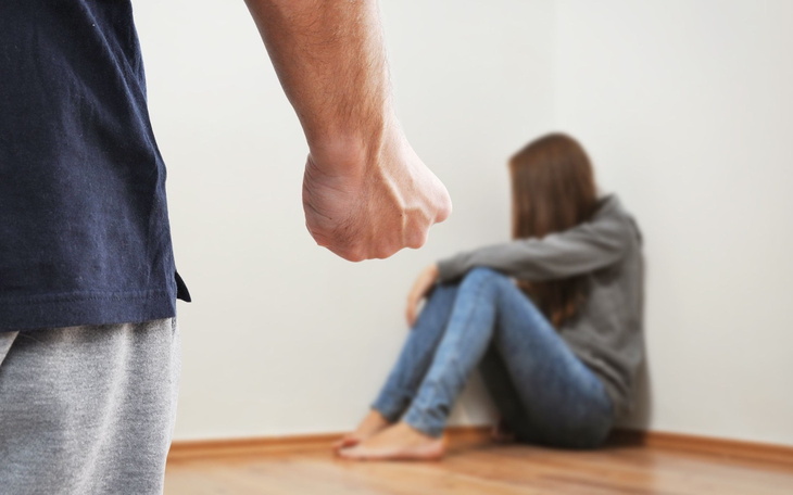 Osoba w trudnej sytuacji, siedząca w kącie pokoju.