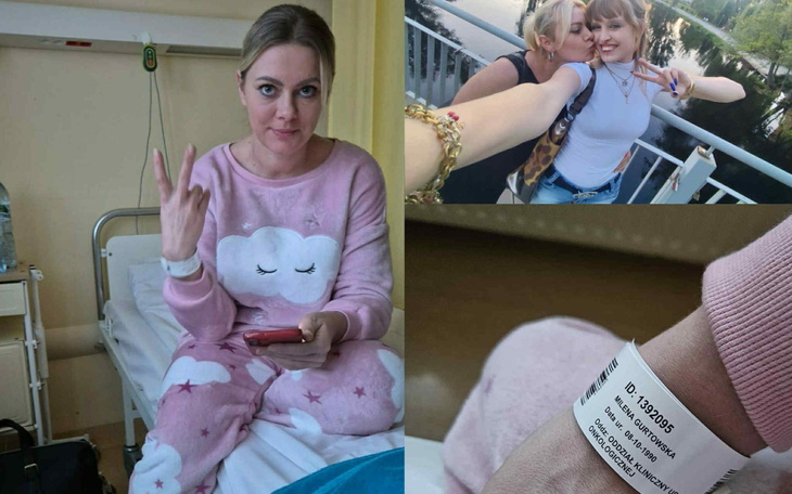 Kobieta w różowym dresie siedzi na łóżku szpitalnym, pokazując znak pokoju.