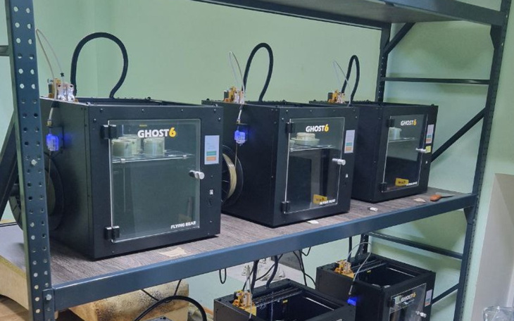 Drukarki 3D ustawione na półce, gotowe do pracy.