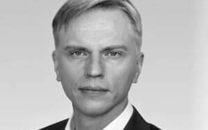 Czarnobiałe zdjęcie mężczyzny w garniturze.