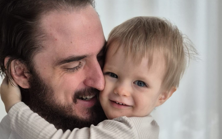 Uśmiechnięty tata przytulający swojego małego synka.