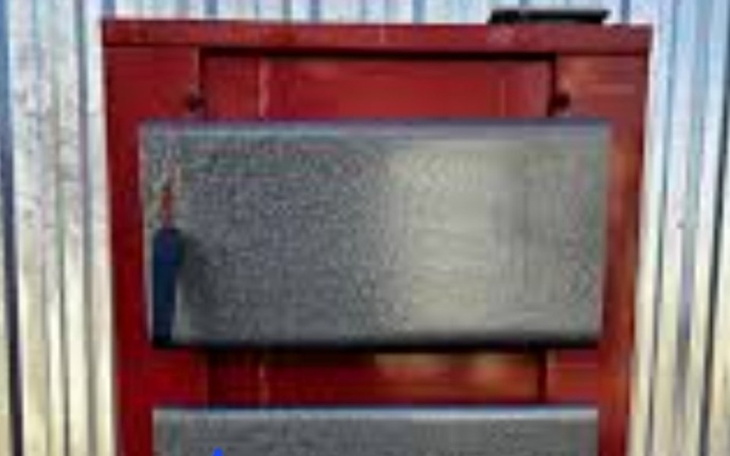 Czerwony kontener z metalowymi drzwiami.