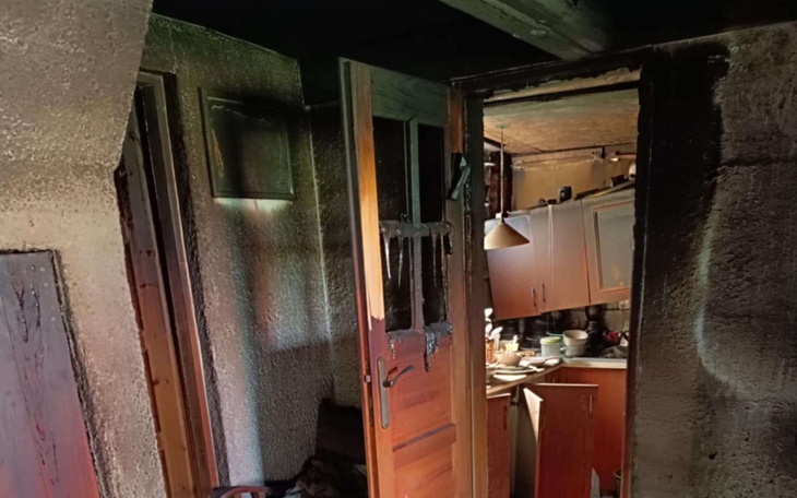 Zniszczona kuchnia po pożarze, z czarnymi ścianami.