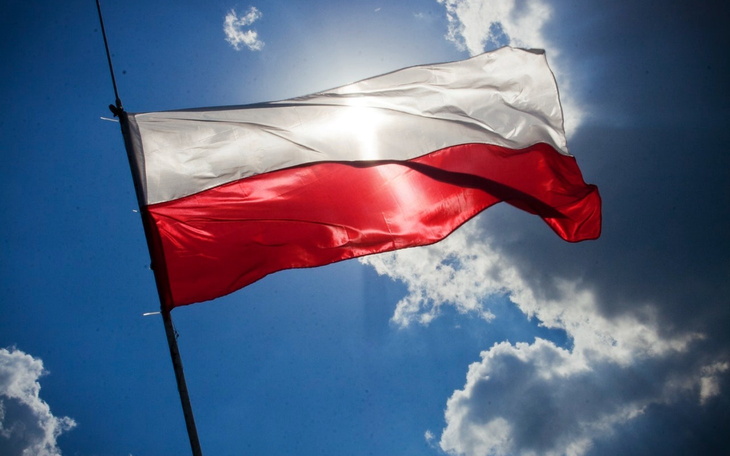 Flaga Polski powiewająca na tle nieba, symbol narodowy.