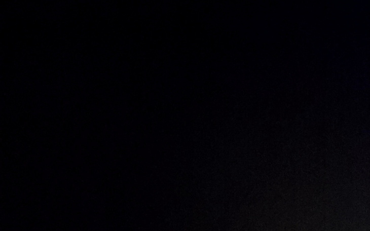 Ciemny kadr z delikatnym światłem w tle.