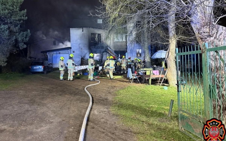Strażacy gaszący pożar w budynku mieszkalnym.