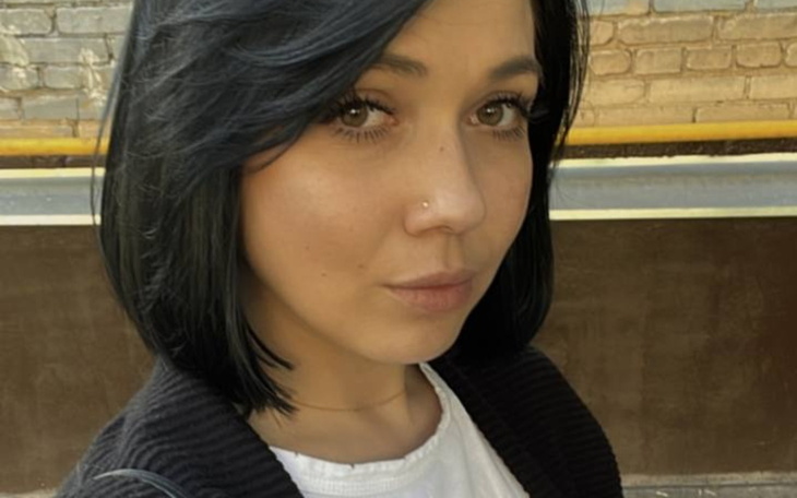 Portret kobiety z krótkimi włosami, uśmiechającej się do kamery.