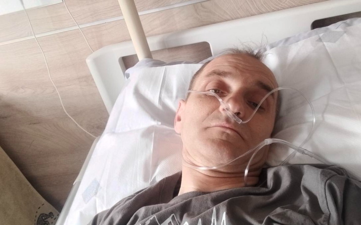 Mężczyzna leżący w łóżku szpitalnym z tlenem.