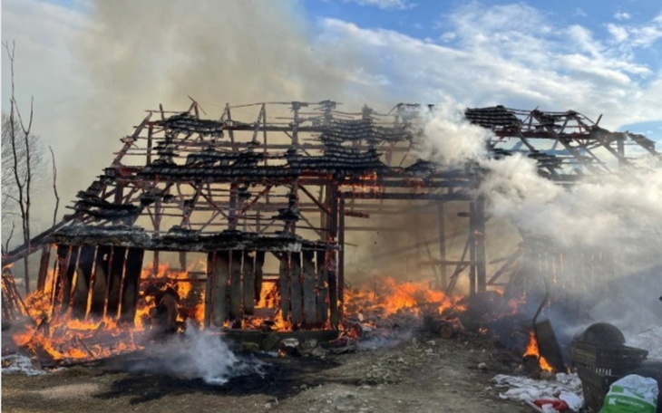 Płonący budynek w otoczeniu dymu i ognia.