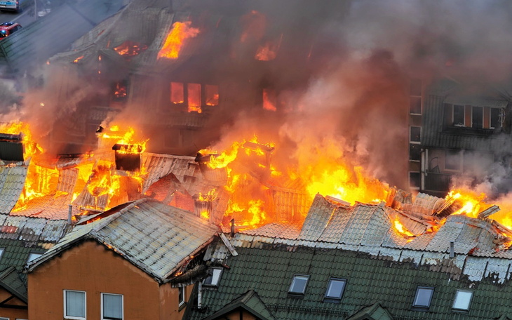 Pożar budynku, ogień i dym w intensywnych kolorach.
