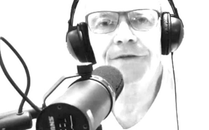 Mężczyzna w słuchawkach, rozmawiający do mikrofonu.