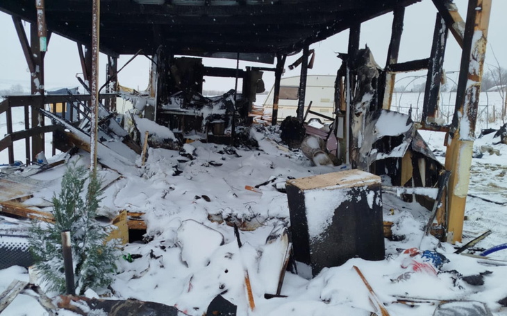 Zniszczony budynek po pożarze, pokryty śniegiem.