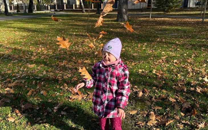 Czarny kot z uszkodzonym okiem leży na podłodze.