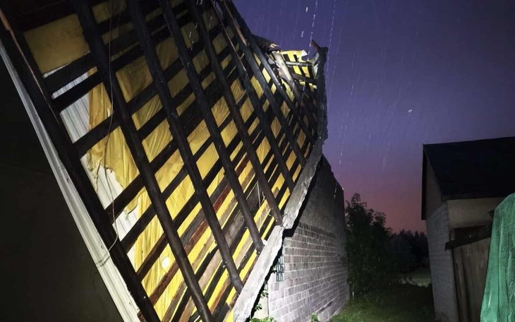 Zniszczony dach budynku po burzy, z widocznymi uszkodzeniami.