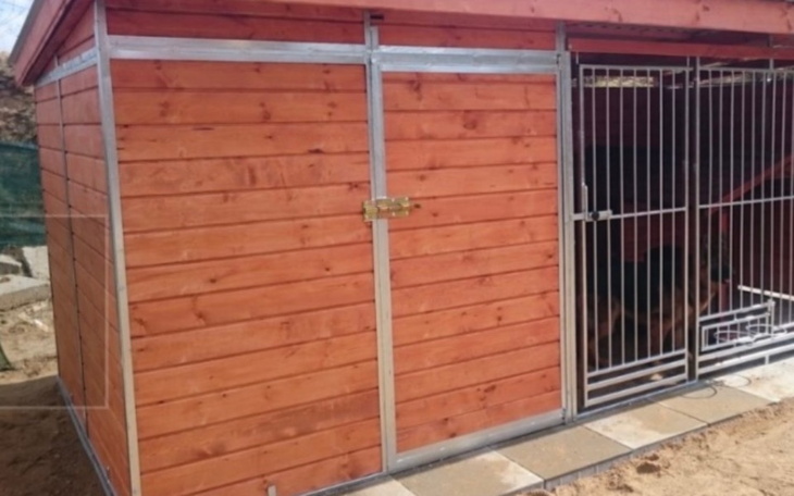 Nowoczesna buda dla psów z metalowymi drzwiami.