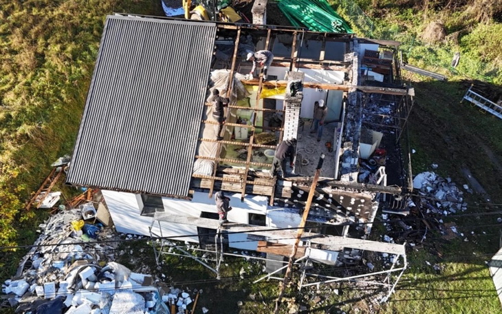Widok z góry na zniszczony dom, w którym pracują ludzie.