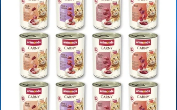 Koci karmnik z popularyzowanym produktem Animonda Carny na tle białych puszek